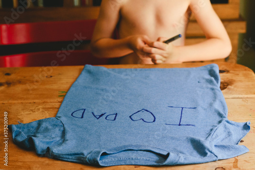 boy making custom father's day shirt