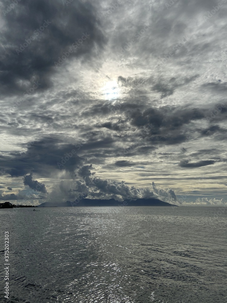 Soleil à travers les nuages sur la mer à Tahiti, Polynésie française