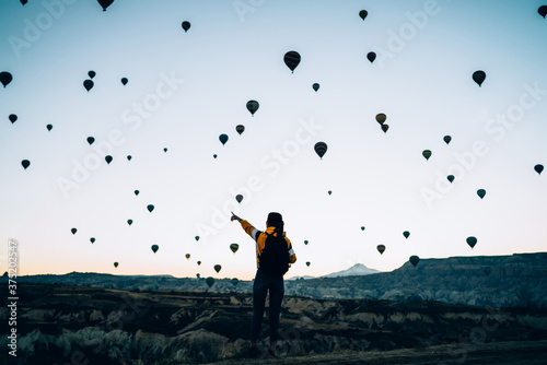Female in rocky terrain with air balloons