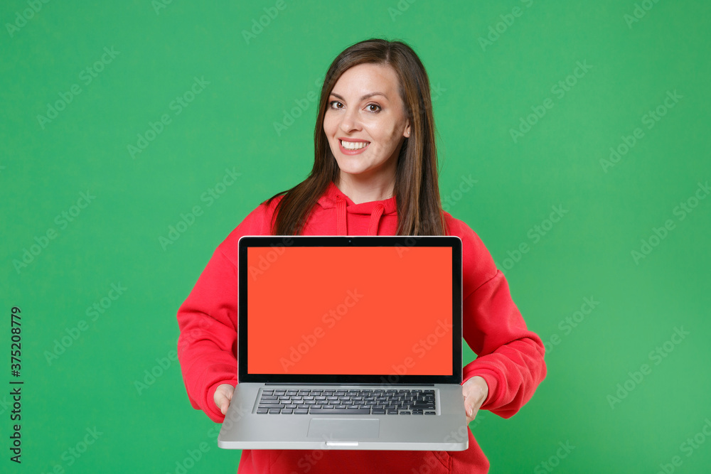 Smiling Young Brunette Woman s Wearing Bright Red Streetwear Hoodie Posing Hold Laptop Pc Computer With Blank Empty Screen Mock Up Copy Space Isolated On Green Color Wall Background Studio Portrait Stock Smiling Young Brunette Woman s Wearing Bright Red Streetwear Hoodie Posing Hold Laptop Pc Computer With Blank Empty Screen Mock Up Copy Space Isolated On Green Color Wall Background Studio Portrait Stock