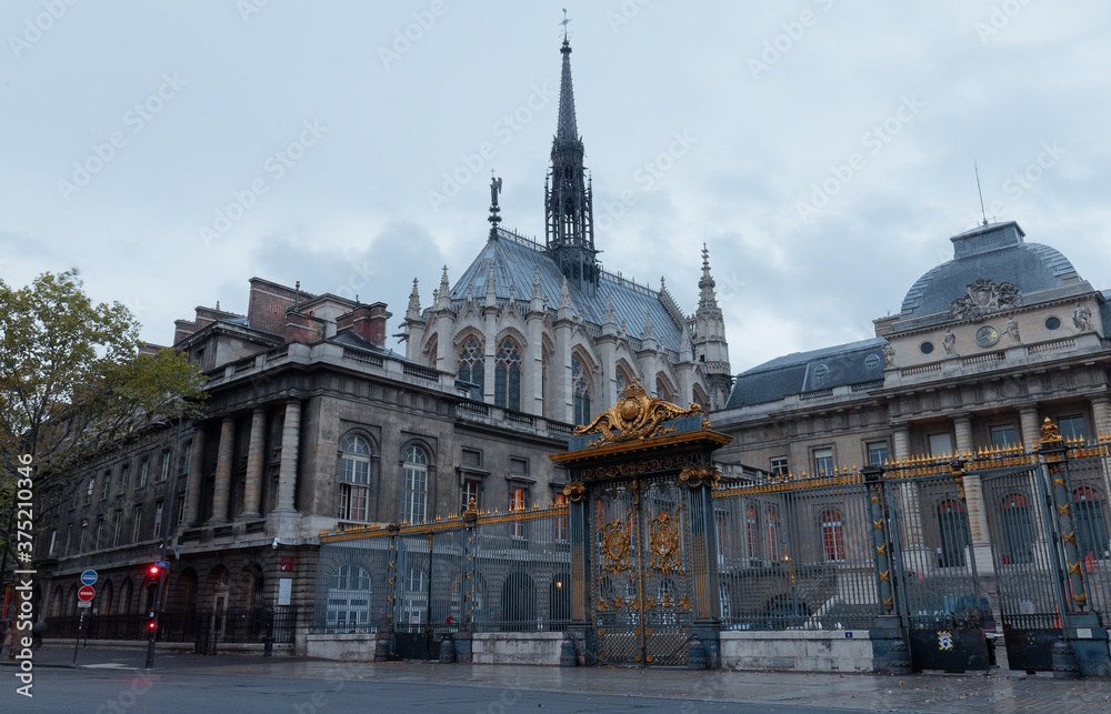 The front entrance of the Palais de Justice and Saint Chapel chapel in Paris, France in rainy summer evening.