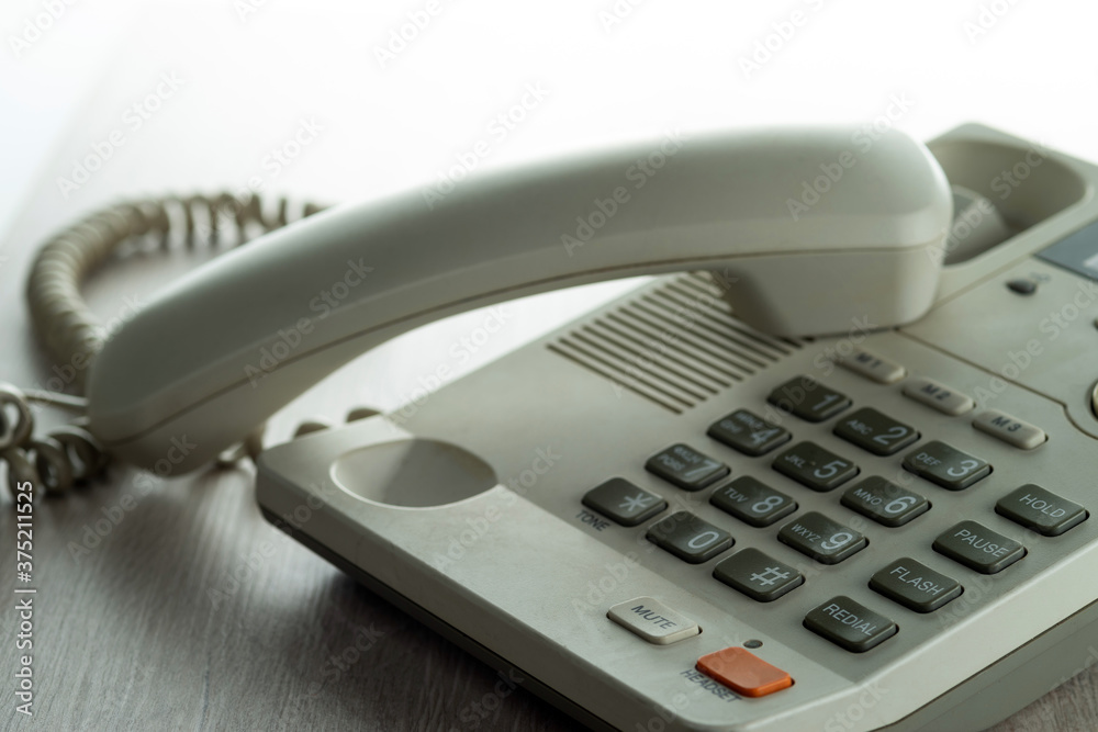 Desk phone on the desk with the handset off. Selective focus. Desk phone on the desk with the handset off. Selective focus.