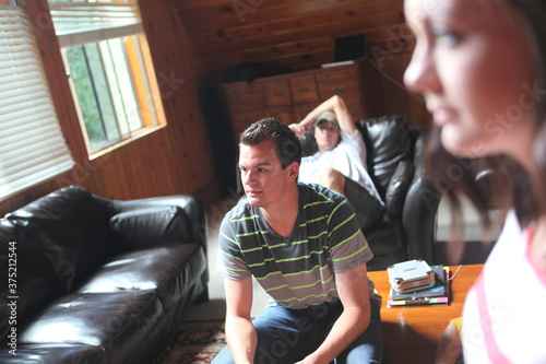 A group of friends or family watching television in living room