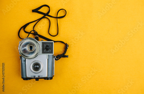 Vintage camera on a yellow background.