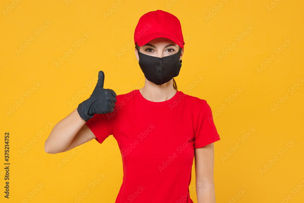 Delivery employee woman in red cap blank t-shirt uniform protect face mask gloves working courier in service during quarantine coronavirus covid-19 virus isolated on yellow background studio portrait.