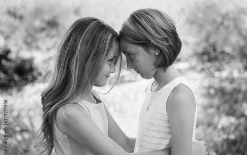 Two young girls facing each other looking eye to eye connecting