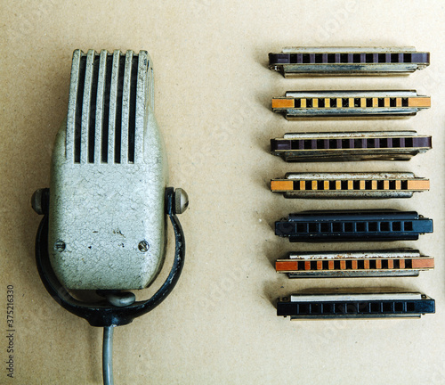 Vintage microphone and blues harmonicas .