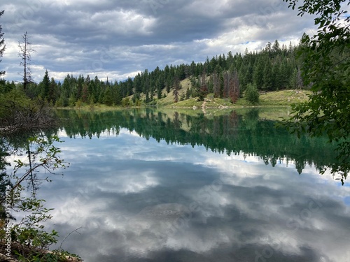 Fototapeta Naklejka Na Ścianę i Meble -  Clouds reflections in beautiful lake with trees