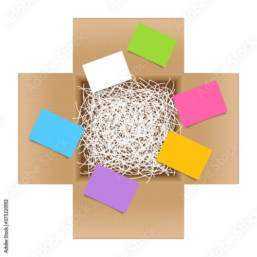 white shredded paper in cardboard box brown open and multi colored paper note sheet, shredded paper in box brown top view for packaging, doodle shredded paper for recycle waste and post note sticky