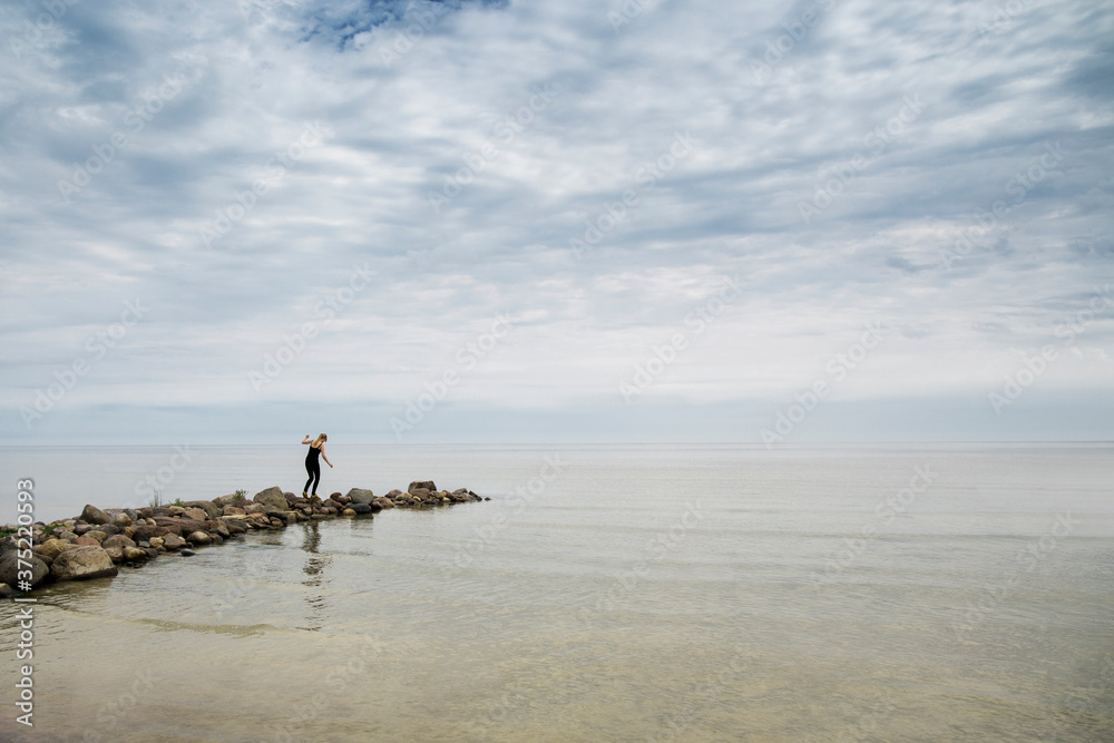 Woman walking on rocks at the beach Woman walking on rocks at the beach