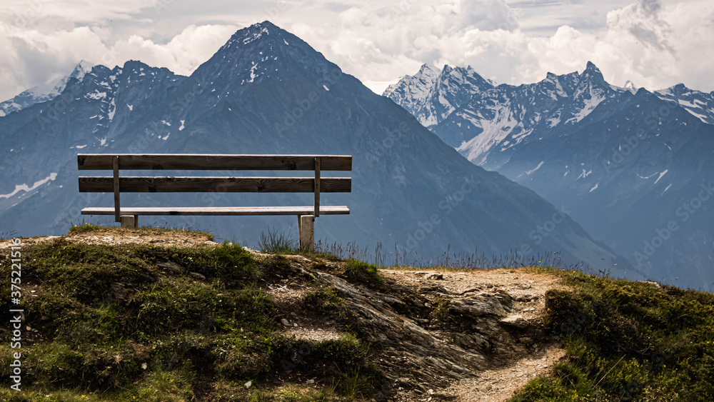Beautiful alpine summer view with a wooden bench at the famous Penken summit, Mayrhofen, Tyrol, Austria