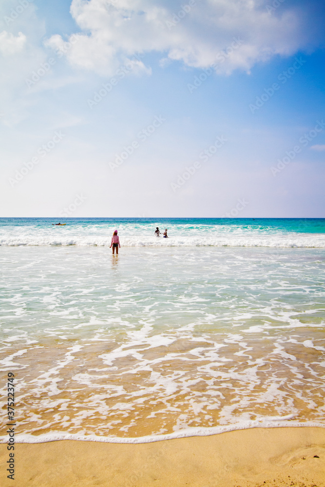 Single girl on the beach as the waves wash in Single girl on the beach as the waves wash in