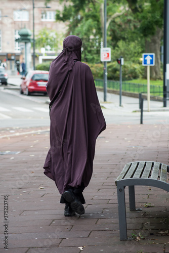 Portrait on back view of muslim woman walking in the street
