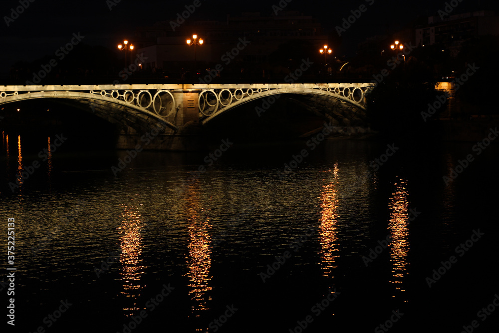 Naklejka premium triana bridge at night with lights sevilla guadalviquir river