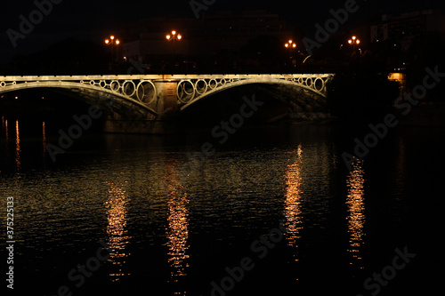 triana bridge at night with lights sevilla guadalviquir river