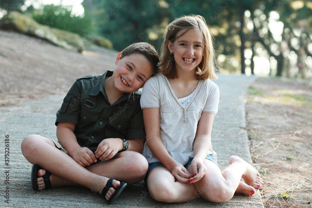 Young boy and girl leaning on each other and laughing Young boy and girl leaning on each other and laughing