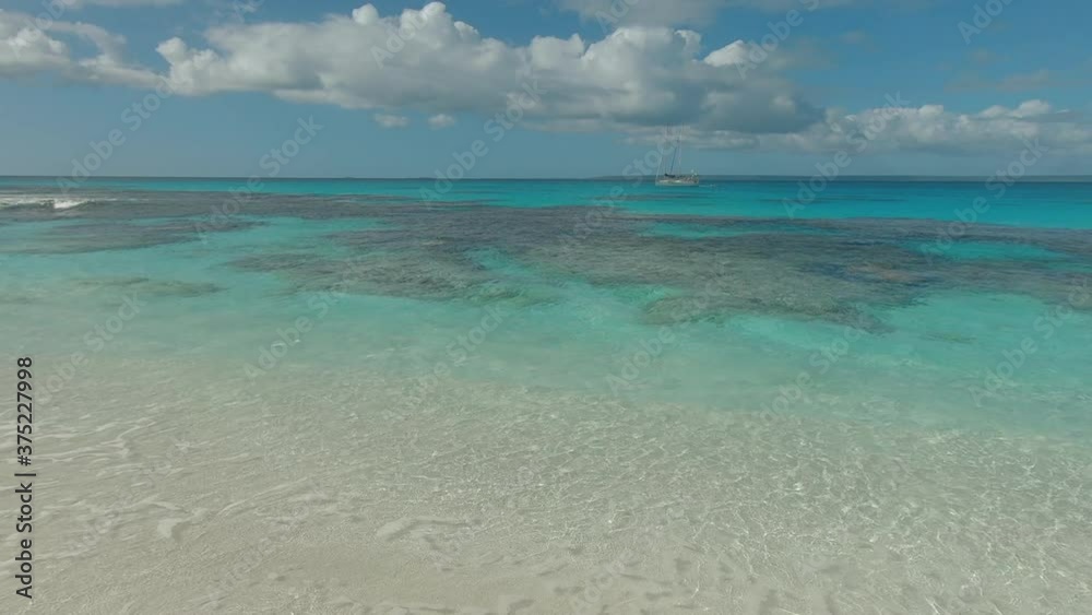 Clear ocean with tropical reef and yacht. High angle aerial Clear ocean with tropical reef and yacht. High angle aerial