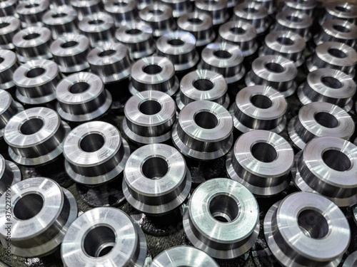 batch of shiny round steel parts background, close-up with selective focus and blur photo