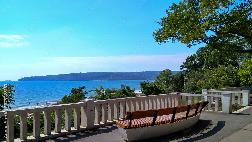 View of the sea from the recreation park, a wooden bench stands  next to the parapet,  beautiful panorama in a quiet place.  