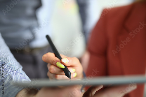Female hand hold black pen and put electronic signature in tablet. Male hand give tablet to take note.