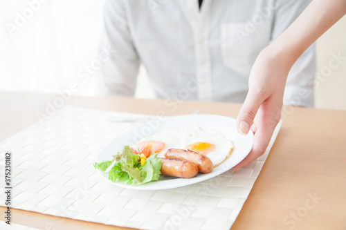 朝食の用意をする男女の手元