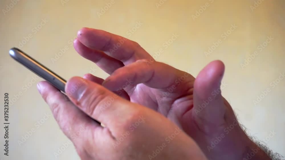 Closeup shot of male hands using modern smartphone device Closeup shot of male hands using modern smartphone device