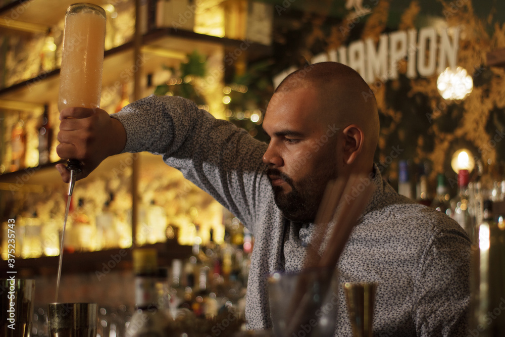 Primer plano de Barman Cantinero mexicano profesional preparando un cóctel alcohólico para los clientes en el bar o discoteca