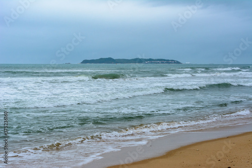 Cloudy day, sand deserted beach of the coast of Haitang Bay in South China Sea. Sanya, island Hainan, China. Nature Landscape.