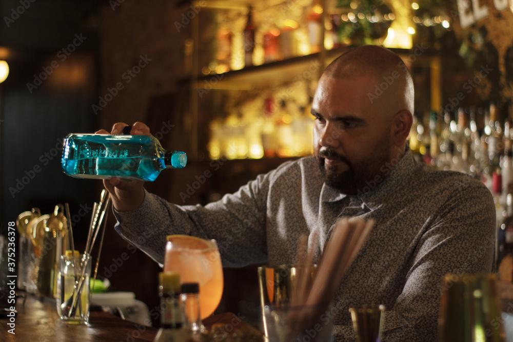 Barman Cantinero mexicano profesional preparando un cóctel alcohólico para los clientes en el bar o discoteca