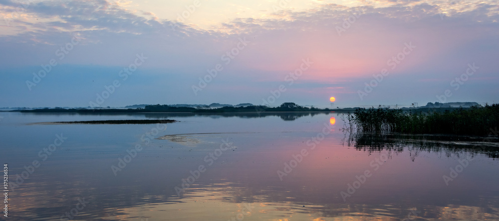 Summer lake sunrise in panoramic landscape