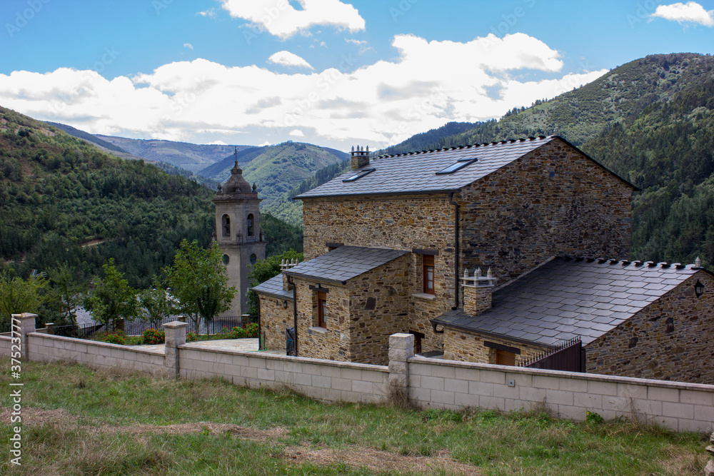 image of the parish church san martin de los oscos with a background of mountains and clouds