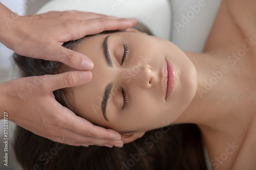 Professional massage therapist massaging forehead of a woman