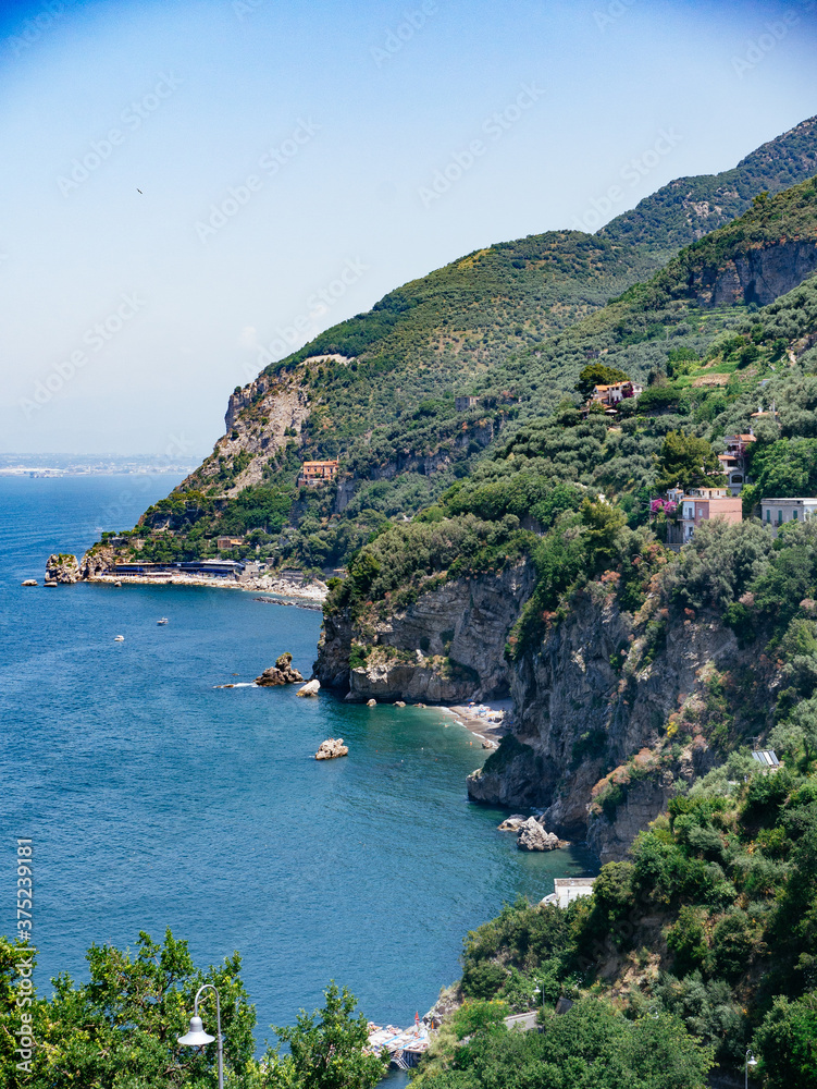 Fototapeta premium Landscape of rocky Mediterranean coast line in south Italy during summer with blue water, green trees and beaches.