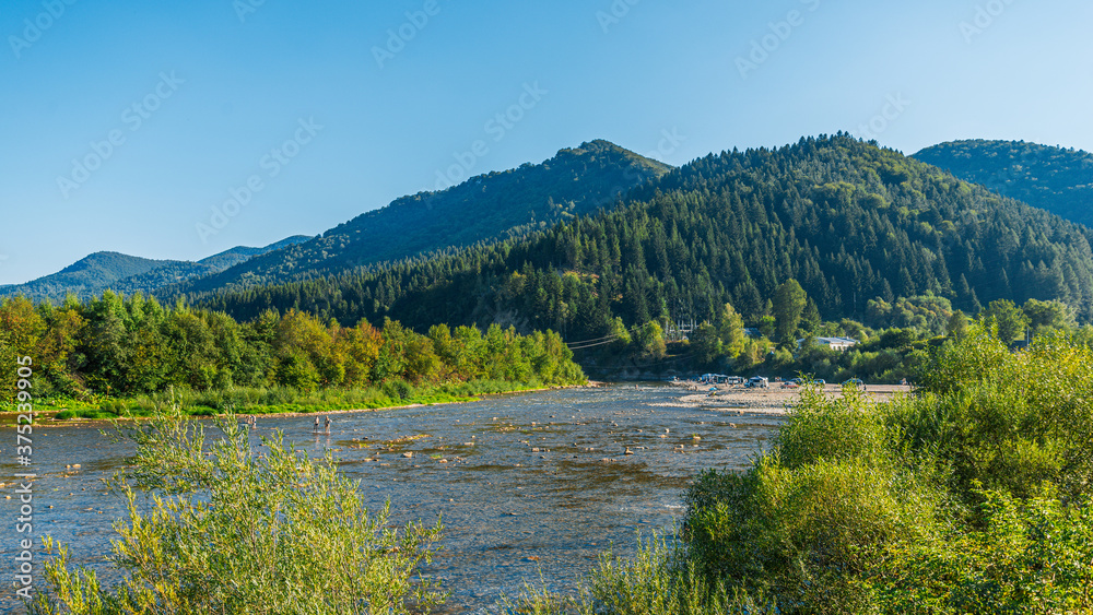 Summer landscape in the Carpathian mountains, the Stryi river in Rybnyk village.