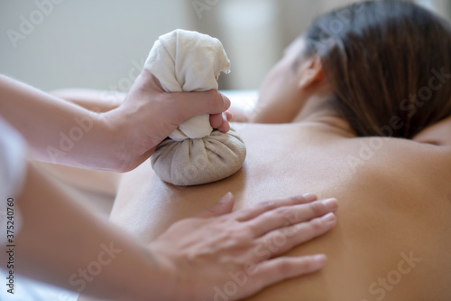 Young dark-haired woman having bags ayurvedic massage