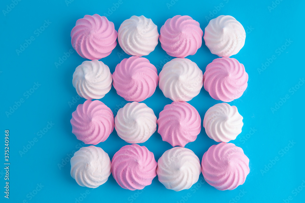 White and pink meringues on a blue background. White and pink meringues on a blue background.