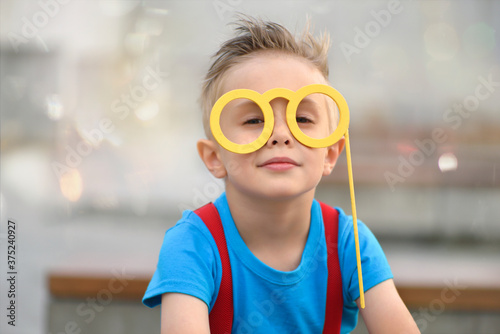Smiling boy with funny glasses on a stick.