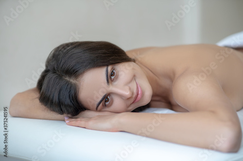 Young woman lying down on a couch and smiling