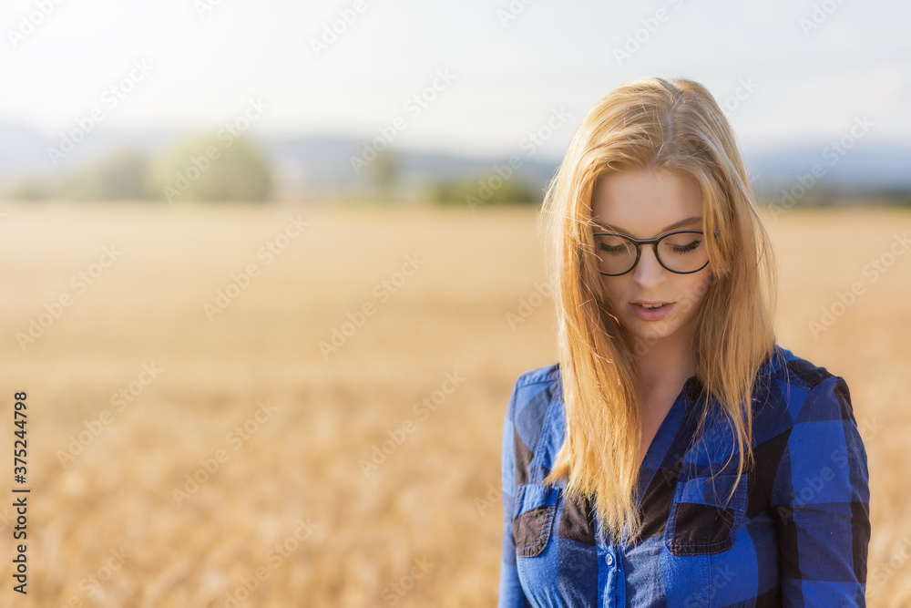 Thoughtful young woman is posing in corn field Thoughtful young woman is posing in corn field