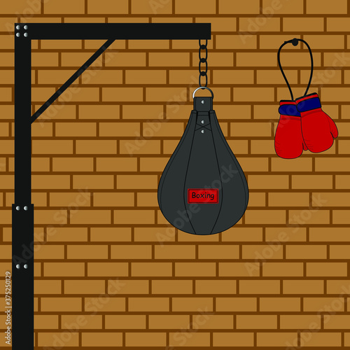 Boxing punching bag and boxing gloves on a brick wall background