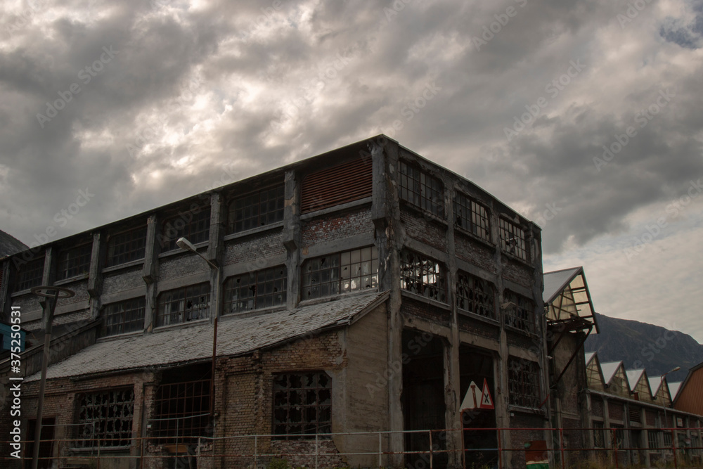 Abandoned factory under a stormy sky