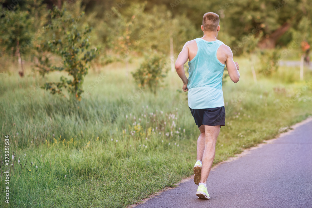 Running sportsman in a park on summer morning.