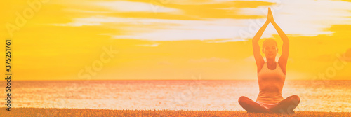 Yoga meditation banner background woman meditating on sunset beach sky with copy space panoramic.