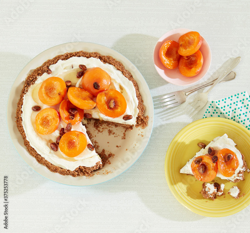 Overhead view of orange and honey cheesecake with apricots on table