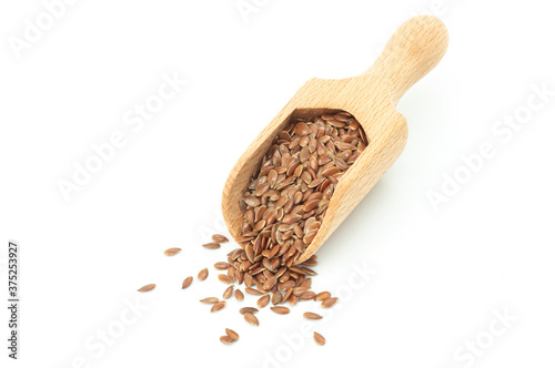 Heap of Flax seeds or linseeds in wooden scoop isolated on white background. Flaxseed concept, dietary fiber 