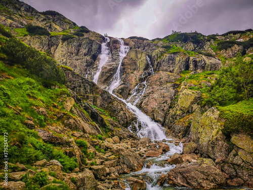 A large waterfall over a rocky cliff 