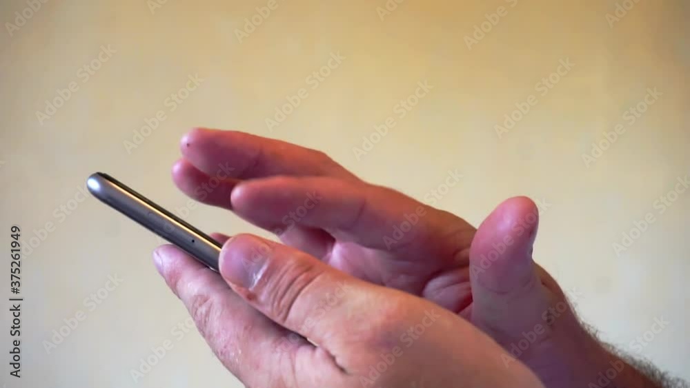 Hands of men using smartphone in the living room at home. Hands of men using smartphone in the living room at home.
