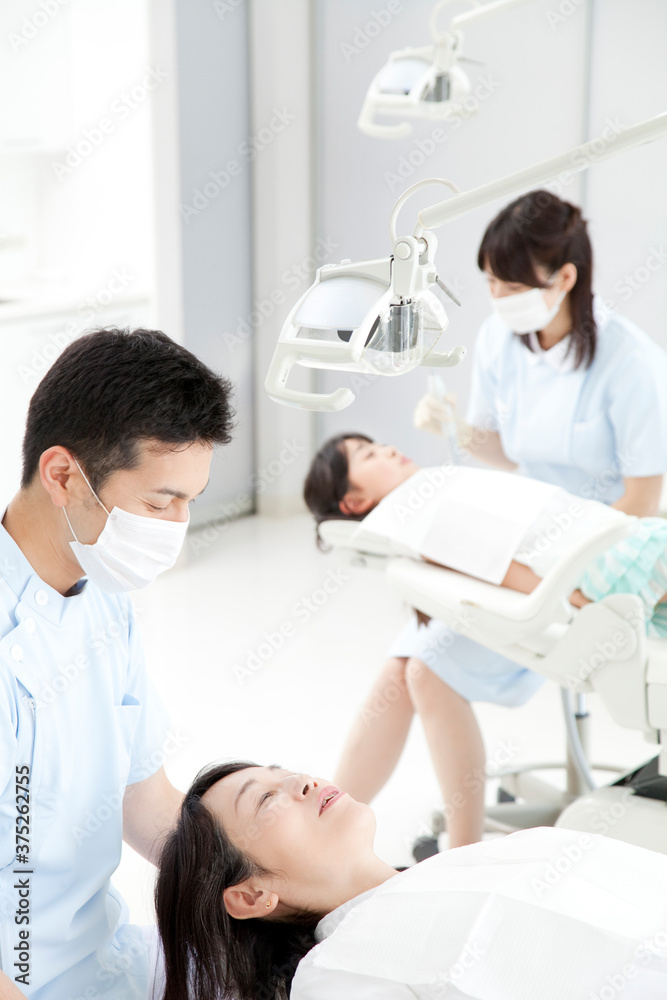 Obraz premium 治療する歯科医