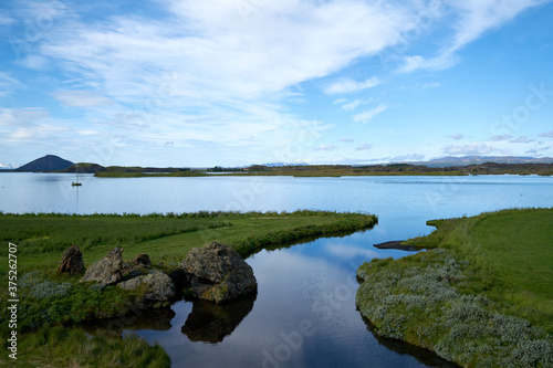 A sunny day on lake Myvatn  Iceland. Clouds reflected in the blue water of a volcanic lake.