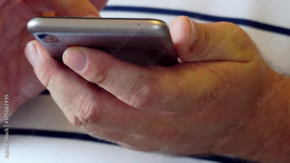 Close up of male hands typing text message on smartphone Close up of male hands typing text message on smartphone